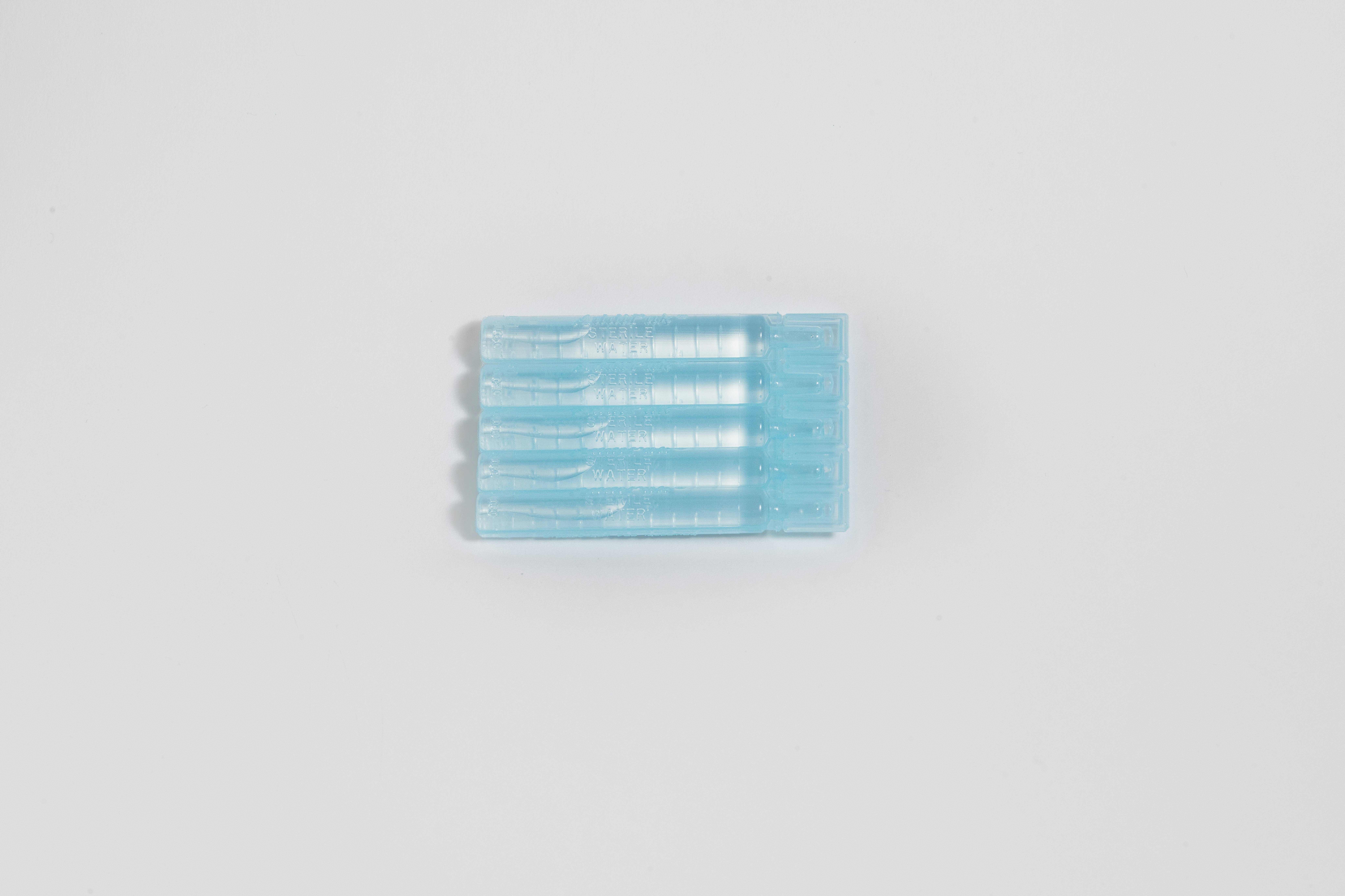 two toothbrushes sitting side by side on a white surface