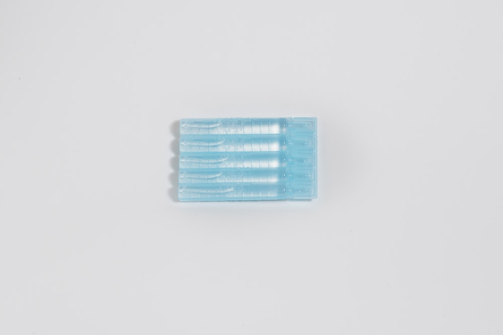 two toothbrushes sitting side by side on a white surface
