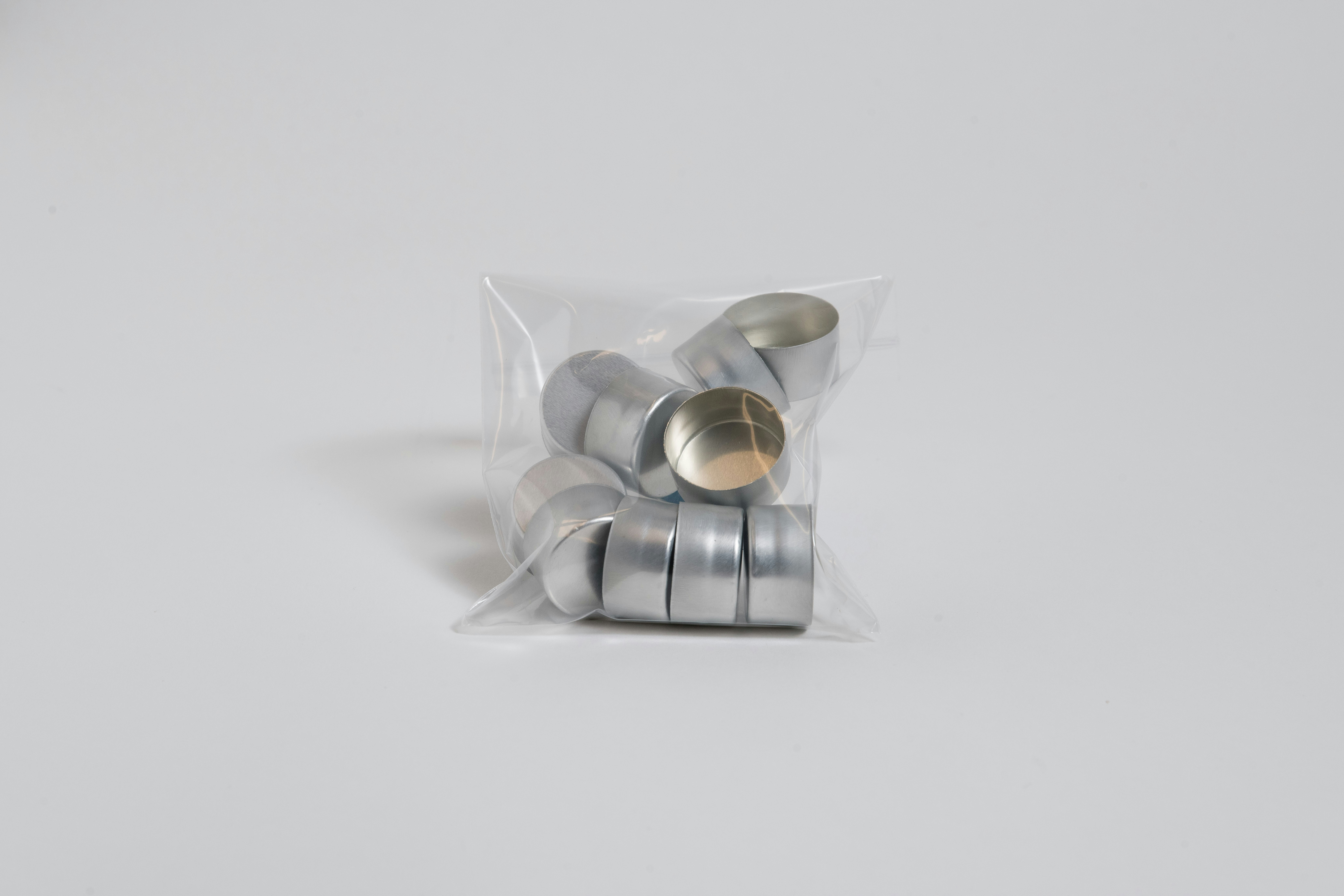 a bag of silver spoons sitting on top of a white table