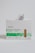 A box of adhesive bandages branded as McKesson, with a simple and clean packaging design. The box has a green checkered pattern and contains fabric strip bandages. A bandage packet is partially pulled out from the box.