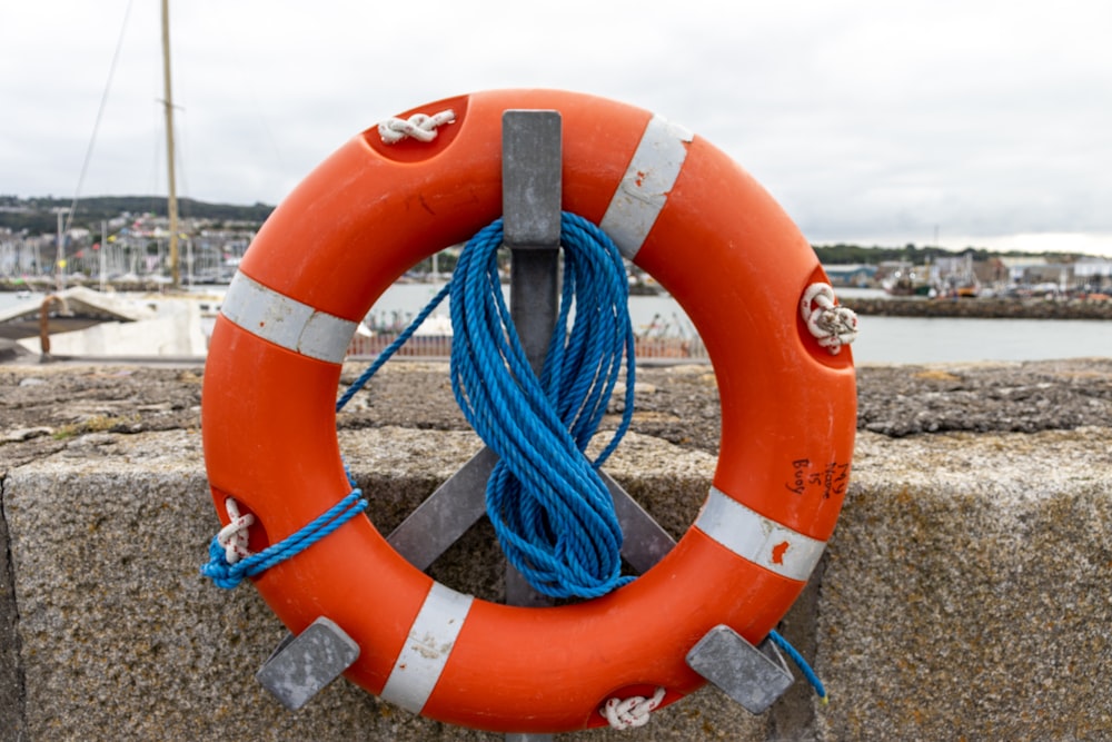 an orange life preserver with a blue rope