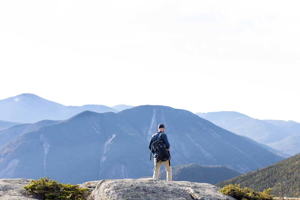 a man standing on top of a large rock