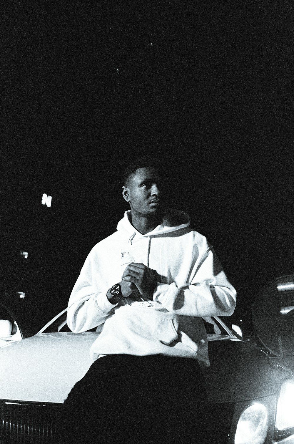 a man sitting on the hood of a car