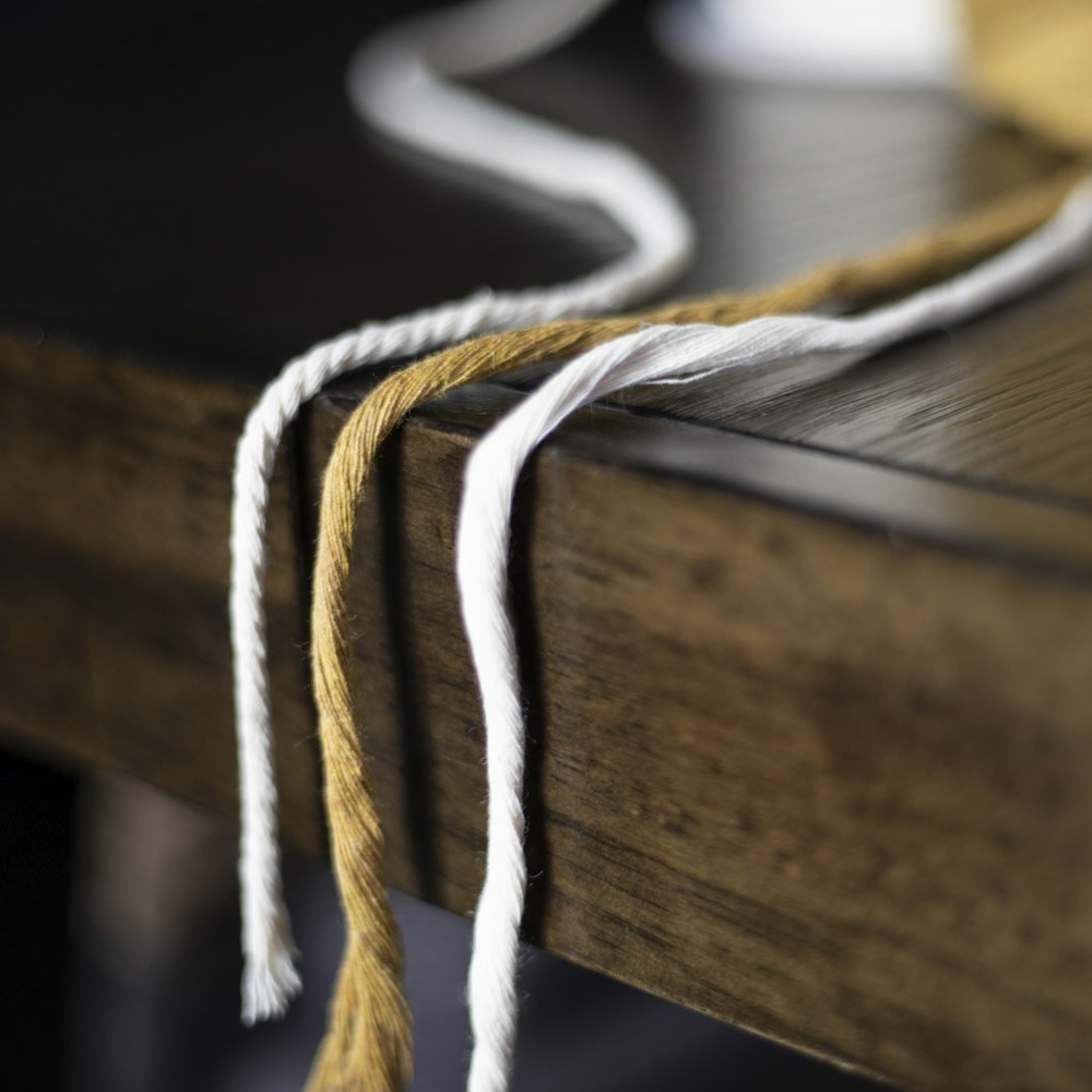 a close up of a wooden bench with a rope