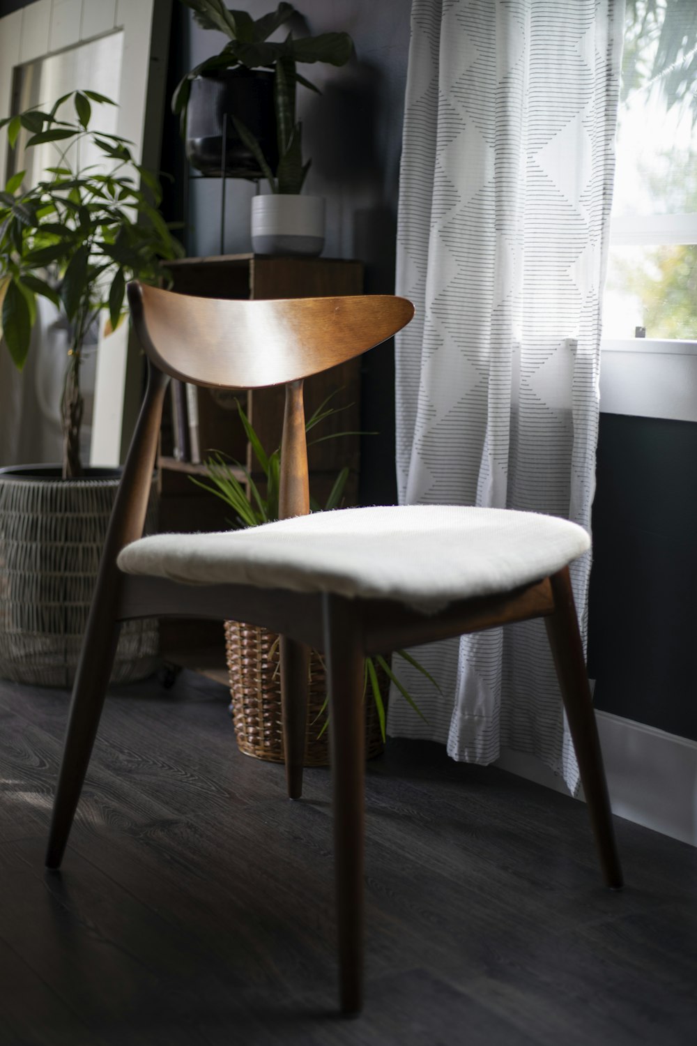 a wooden chair sitting in front of a window