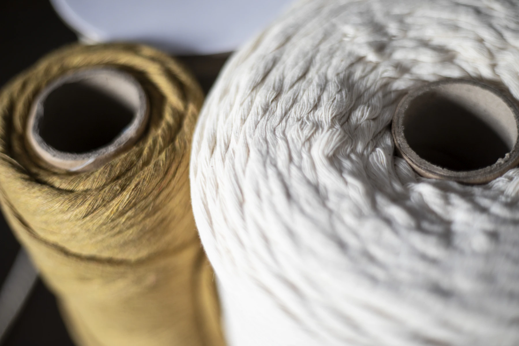 Deux pelotes de fibres naturelles posées sur une surface claire, lumière du matin