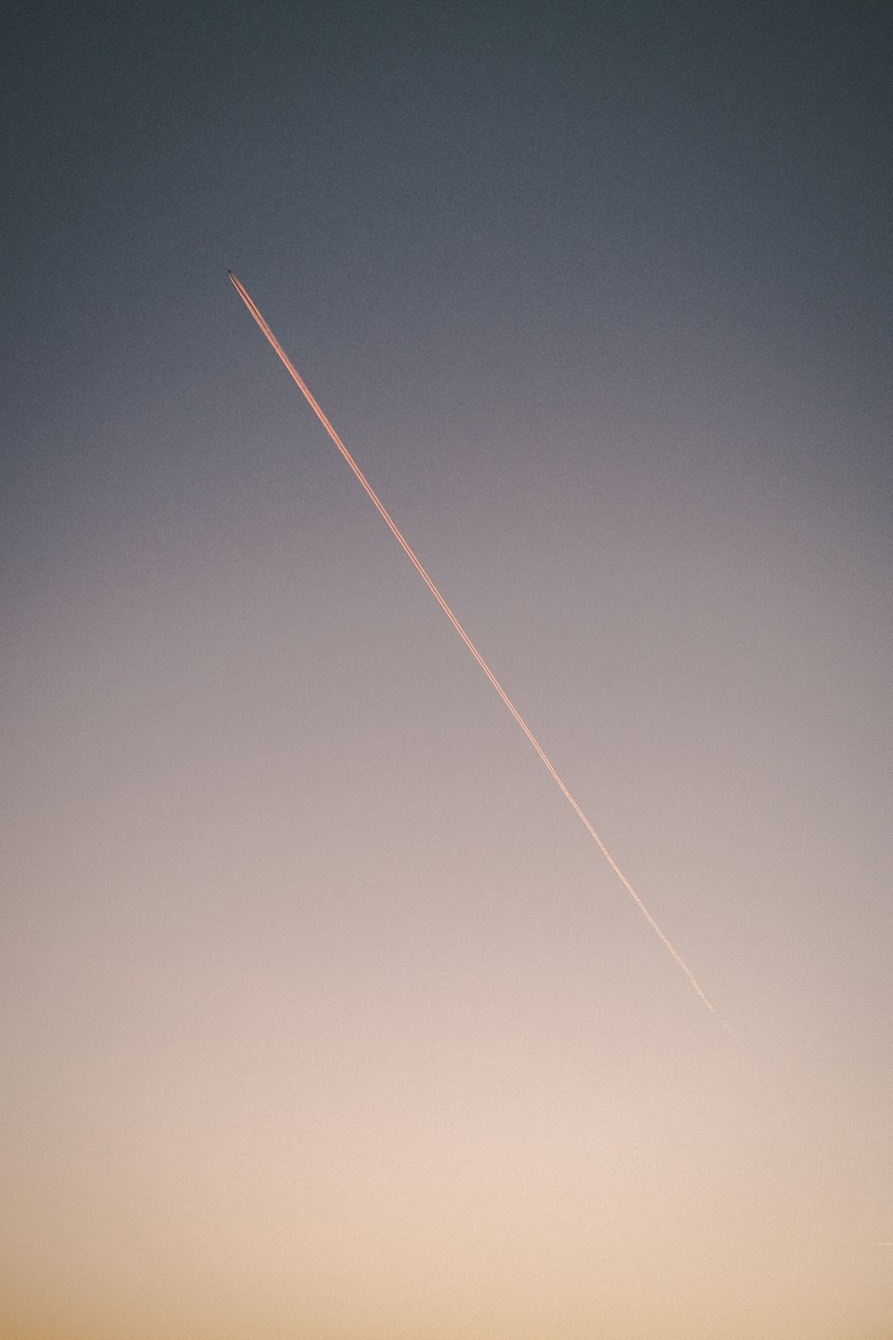 an airplane is flying in the sky at sunset