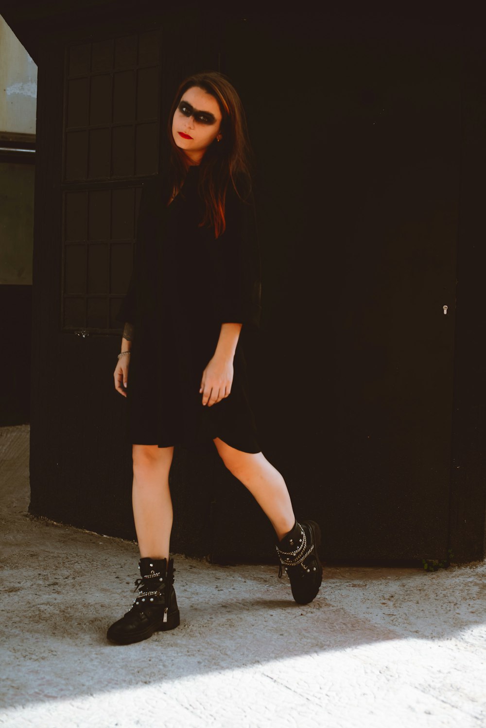 a woman in a black dress and black boots