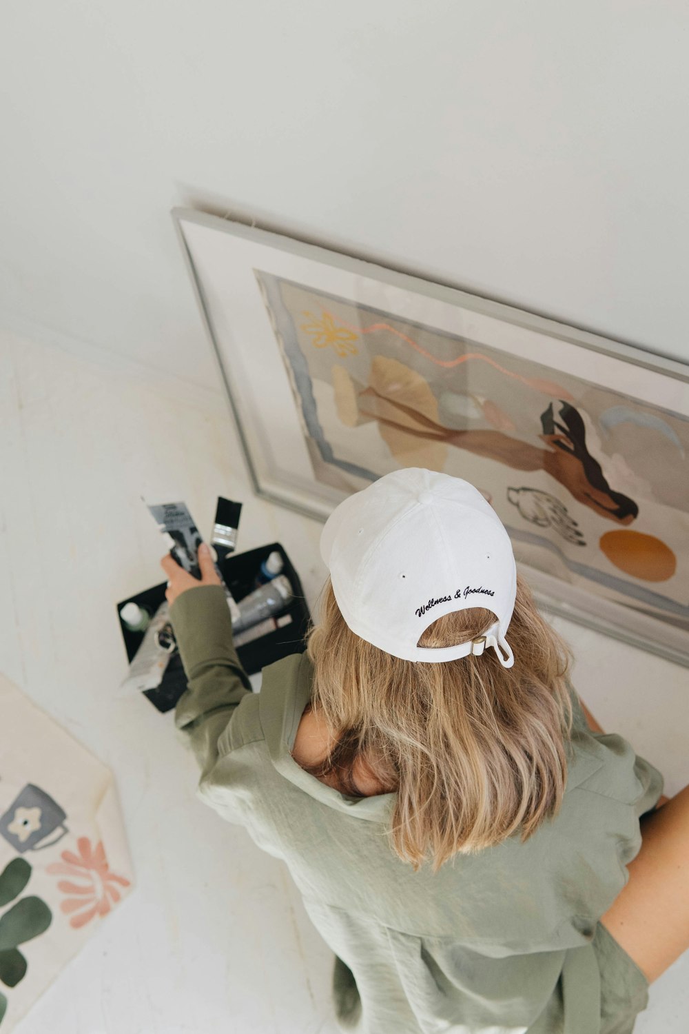 Une femme portant un chapeau blanc et tenant un appareil photo