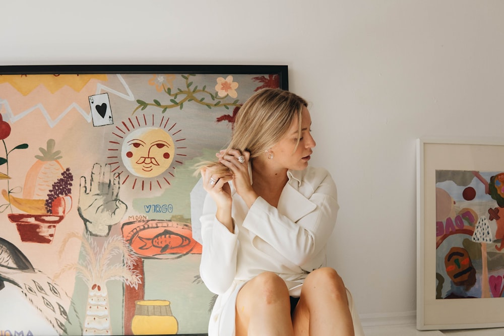 a woman sitting on a chair in front of a painting