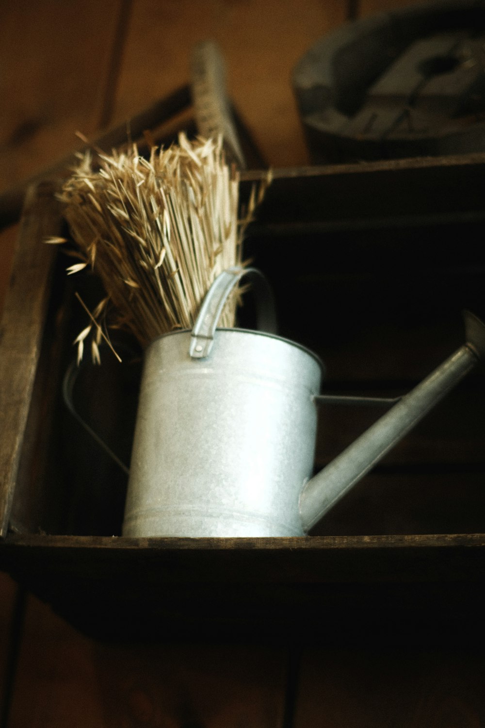 a metal watering can with a straw in it