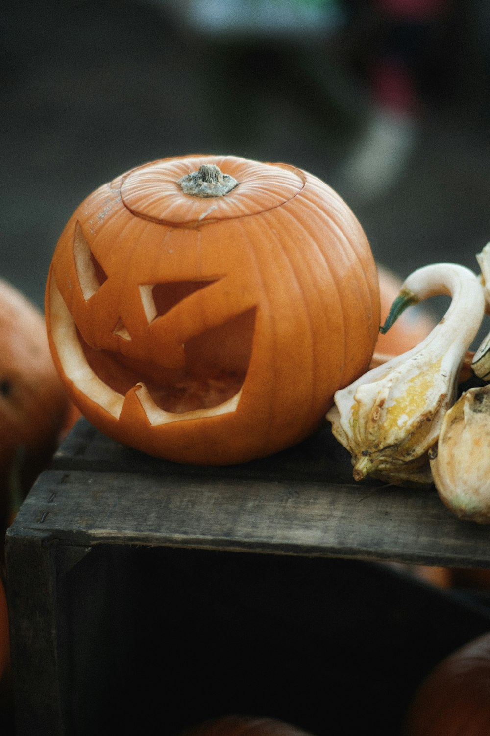 Una calabaza tallada sentada encima de una mesa de madera