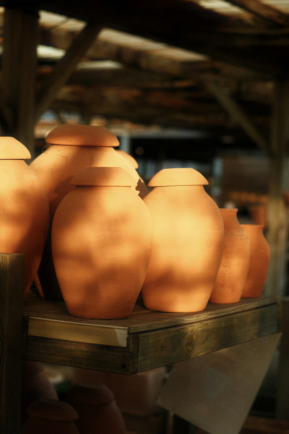 a group of clay pots sitting on top of a wooden shelf
