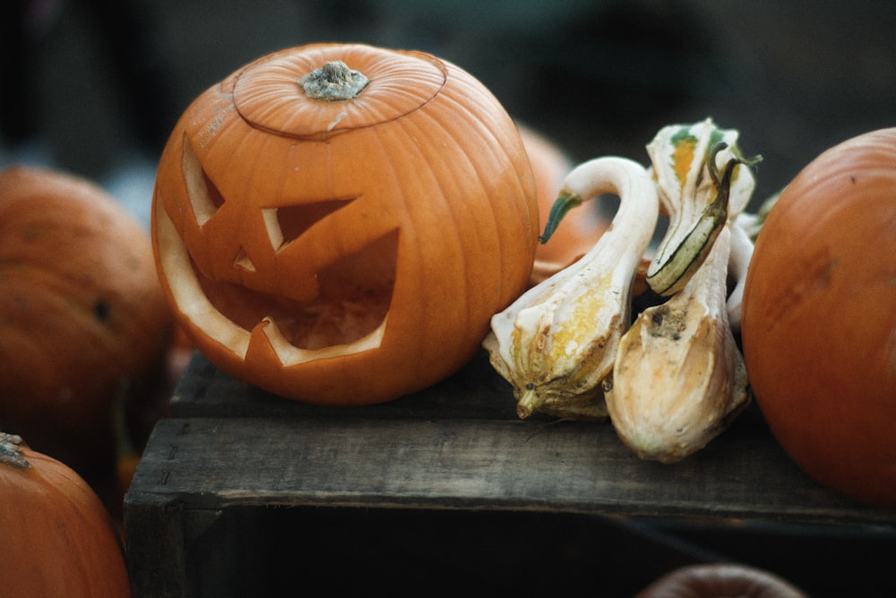 una zucca intagliata seduta sopra un tavolo di legno