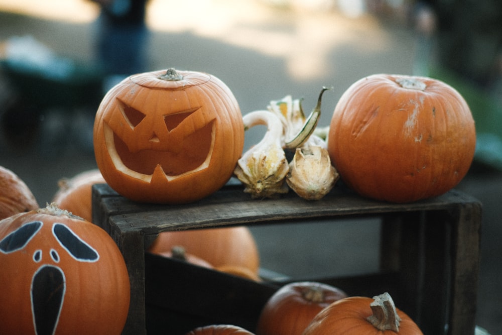 a group of pumpkins sitting on top of a wooden table