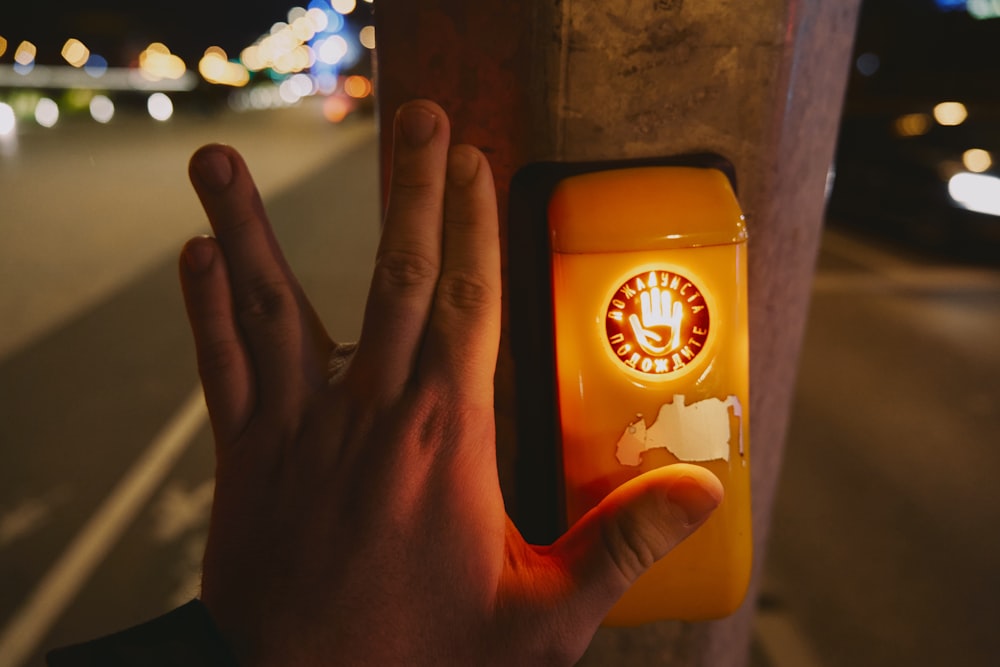 a person is holding their hand up to a button with a clock on it