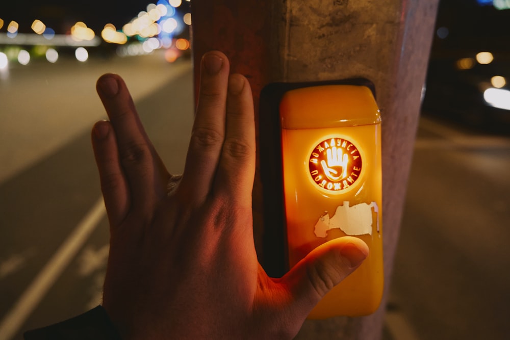 Una persona está sosteniendo su mano hacia un botón con un reloj en él
