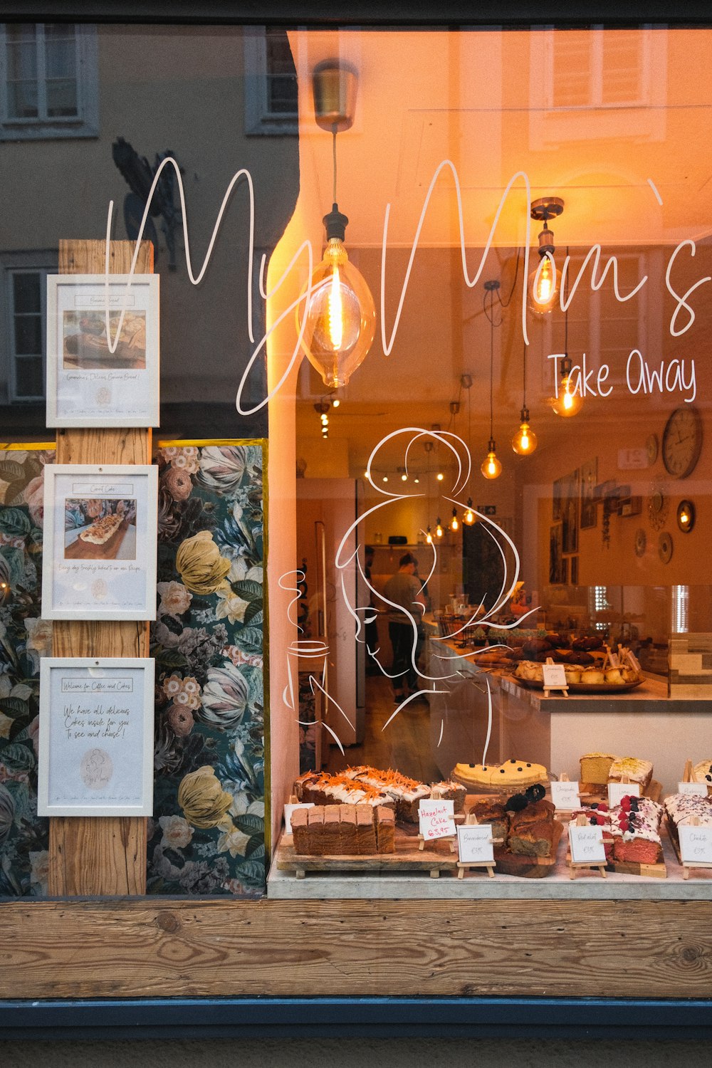 a bakery window with a display of cakes and pastries