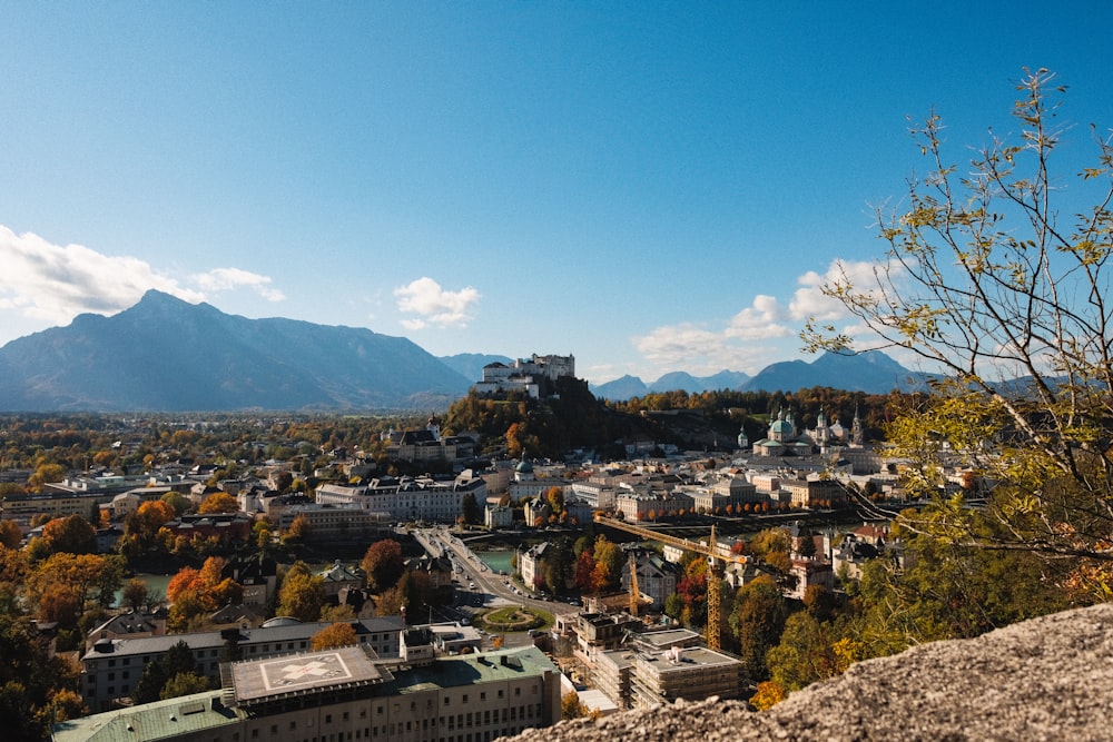 a scenic view of a city with mountains in the background