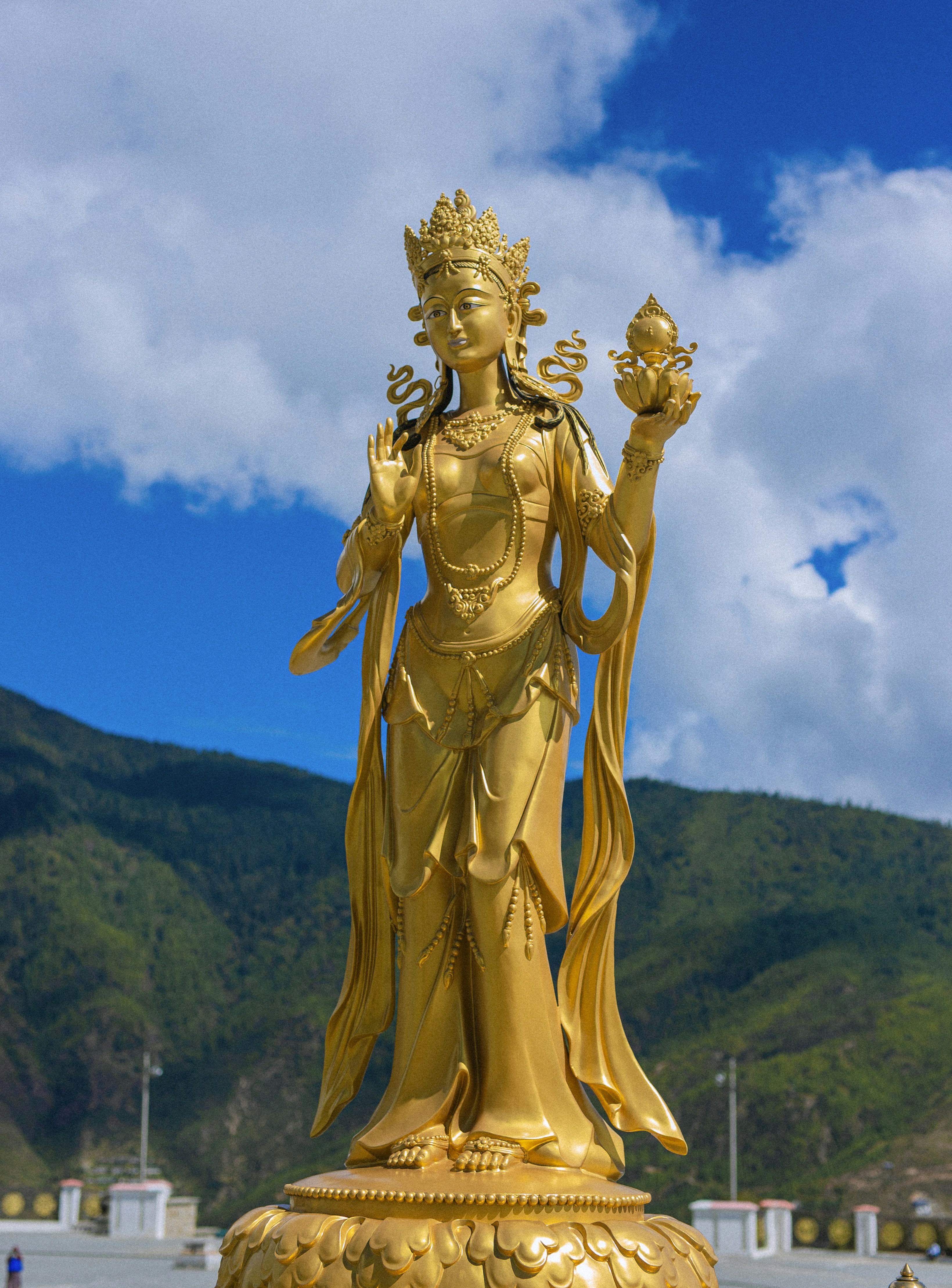 una statua dorata di una donna che tiene un fiore
