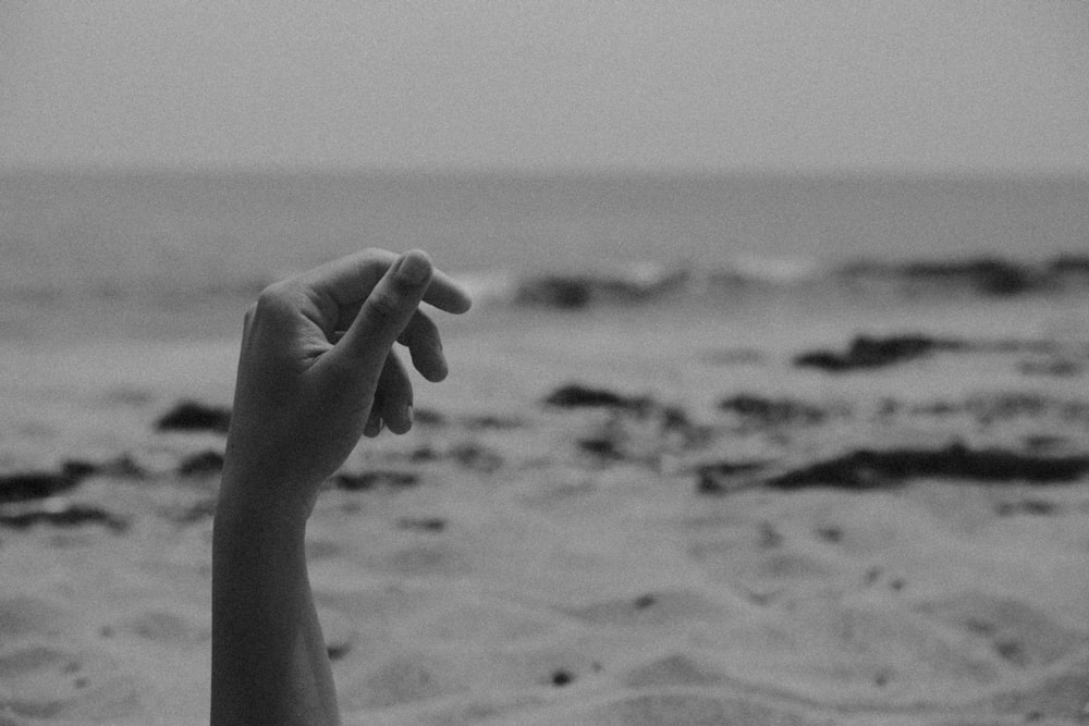 a black and white photo of a hand reaching for something