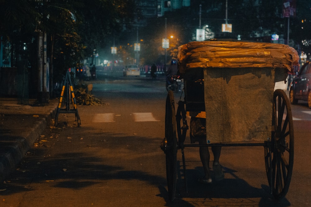 uma carruagem puxada por cavalos em uma rua da cidade à noite
