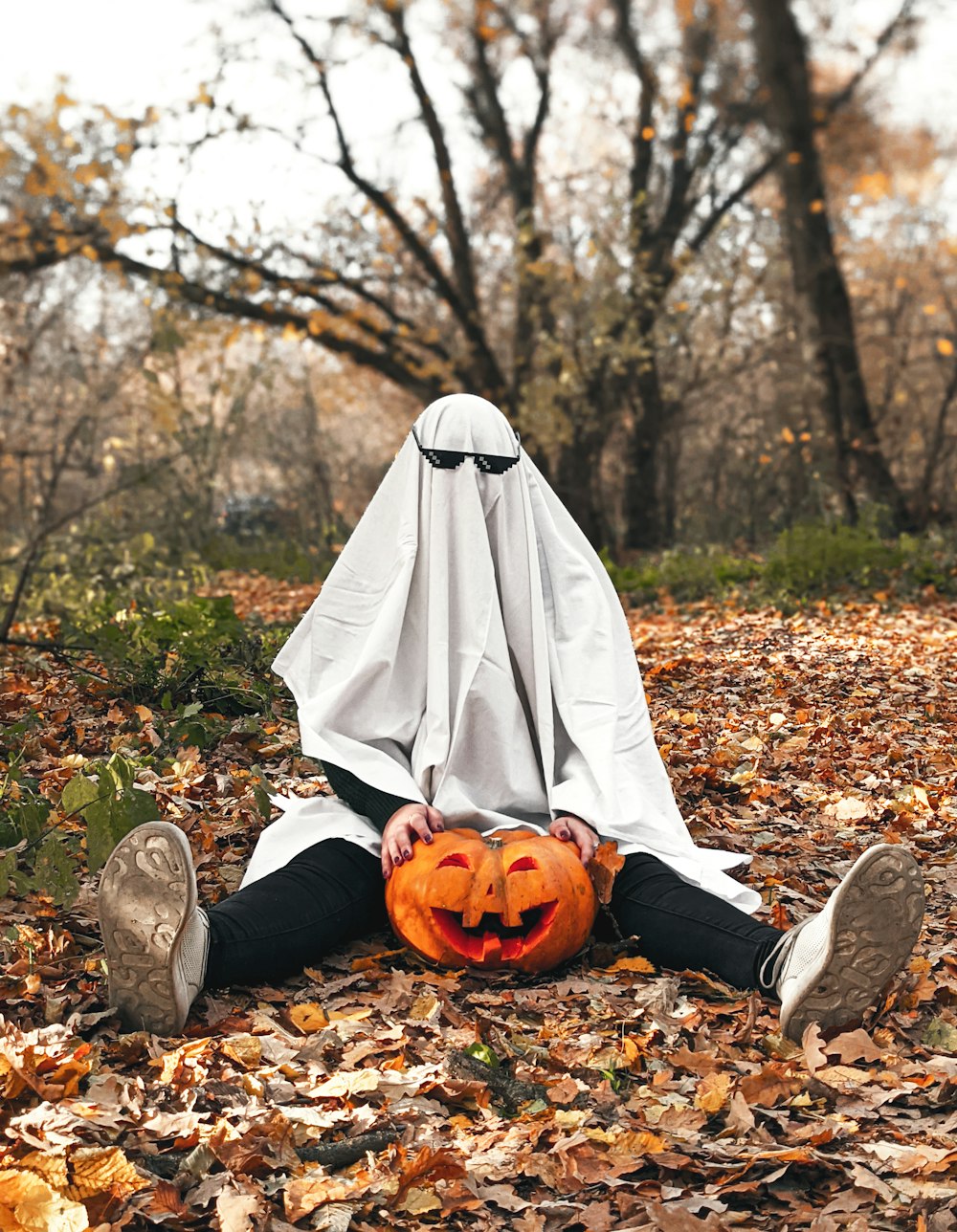 a person sitting on the ground covered in leaves