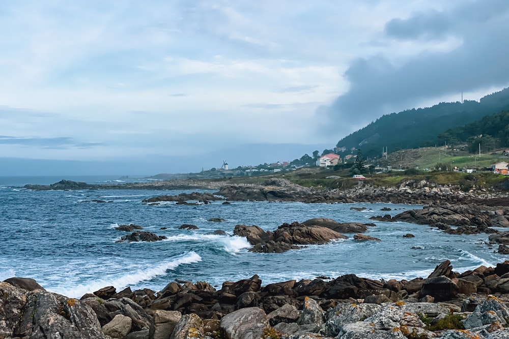 a view of a rocky shore with houses in the distance