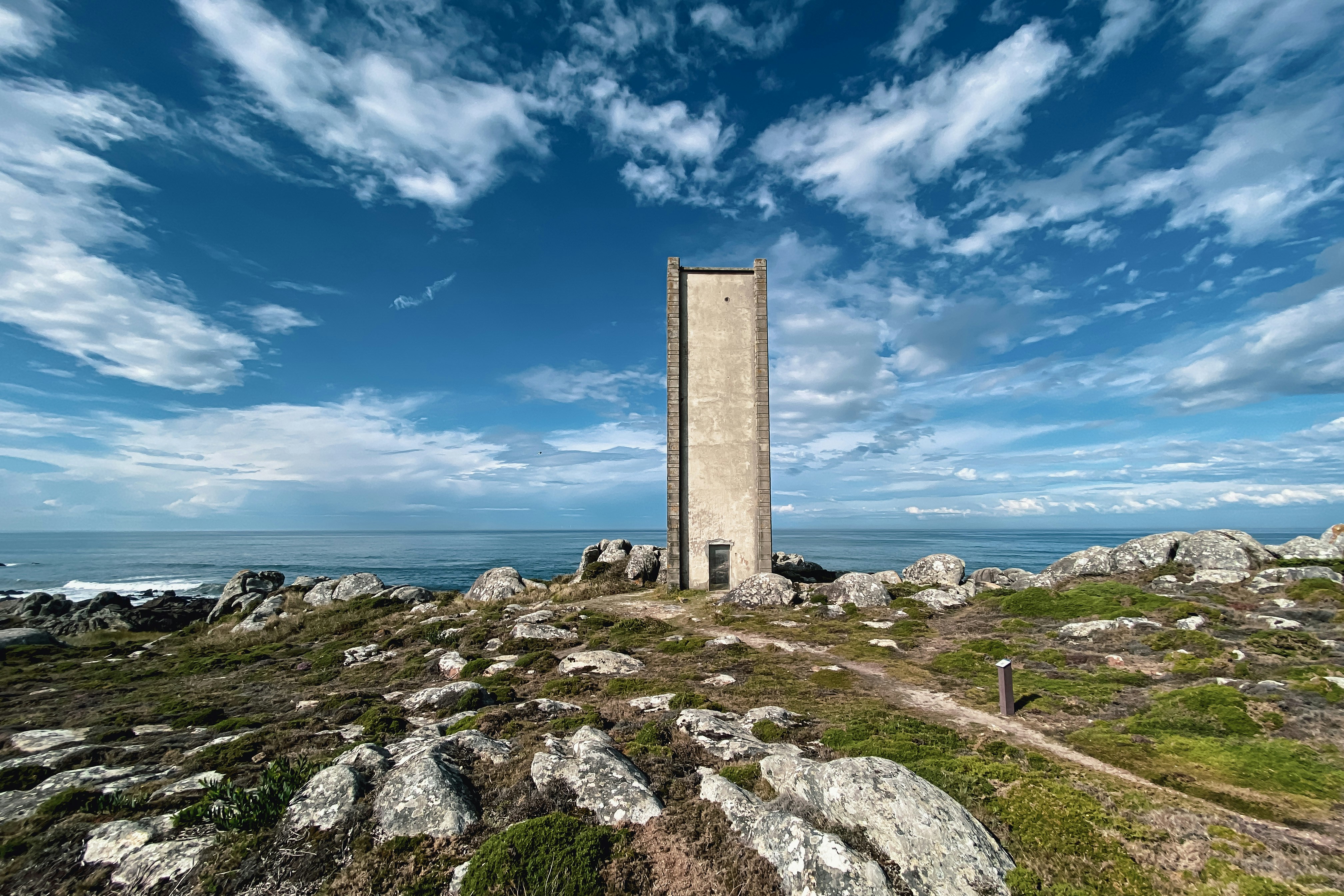 Landmark · a tall tower sitting on top of a lush green hillside