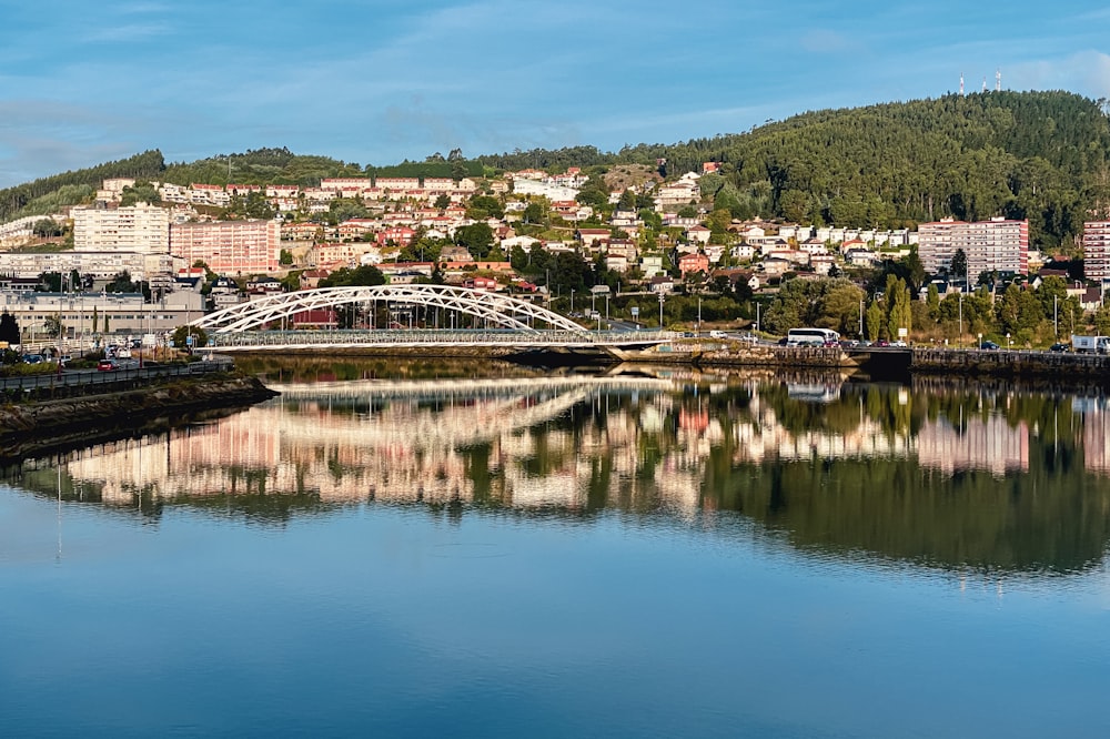 a bridge over a river with a city in the background