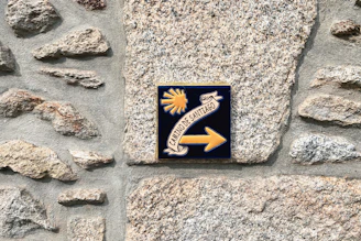 a sign on a stone wall pointing to the right
