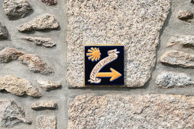 a sign on a stone wall pointing to the right