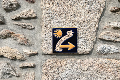 a sign on a stone wall pointing to the right