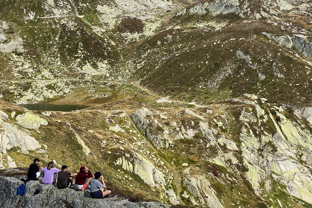 a group of people sitting on top of a mountain