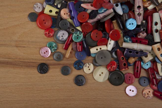 Close-up of colorful sewing buttons arranged neatly on a wooden table.