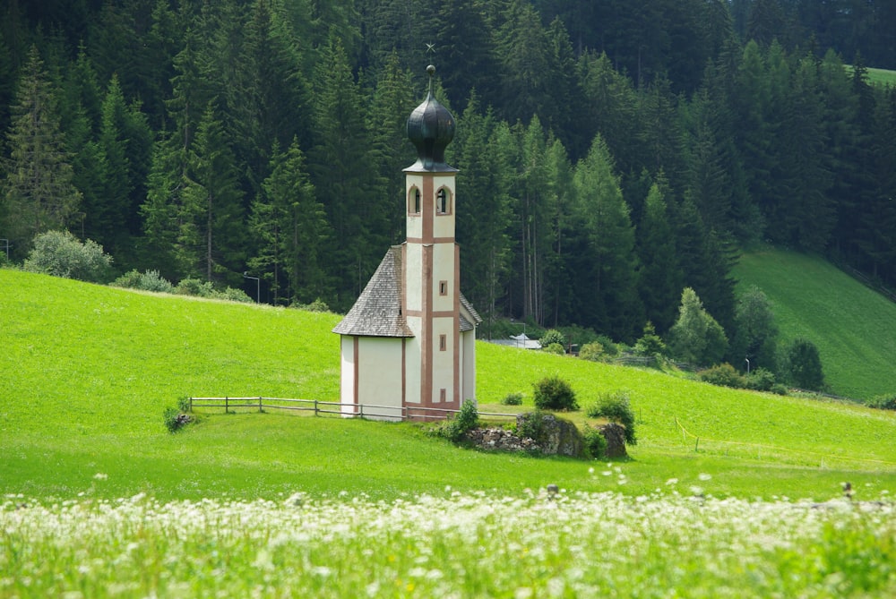 a small church in the middle of a green field