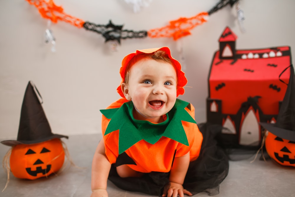 a baby in a halloween costume sitting on the floor