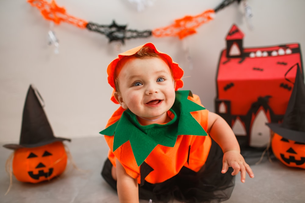 a baby in a halloween costume sitting on the floor