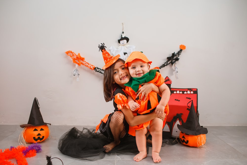 Una donna che tiene un bambino in un costume di Halloween