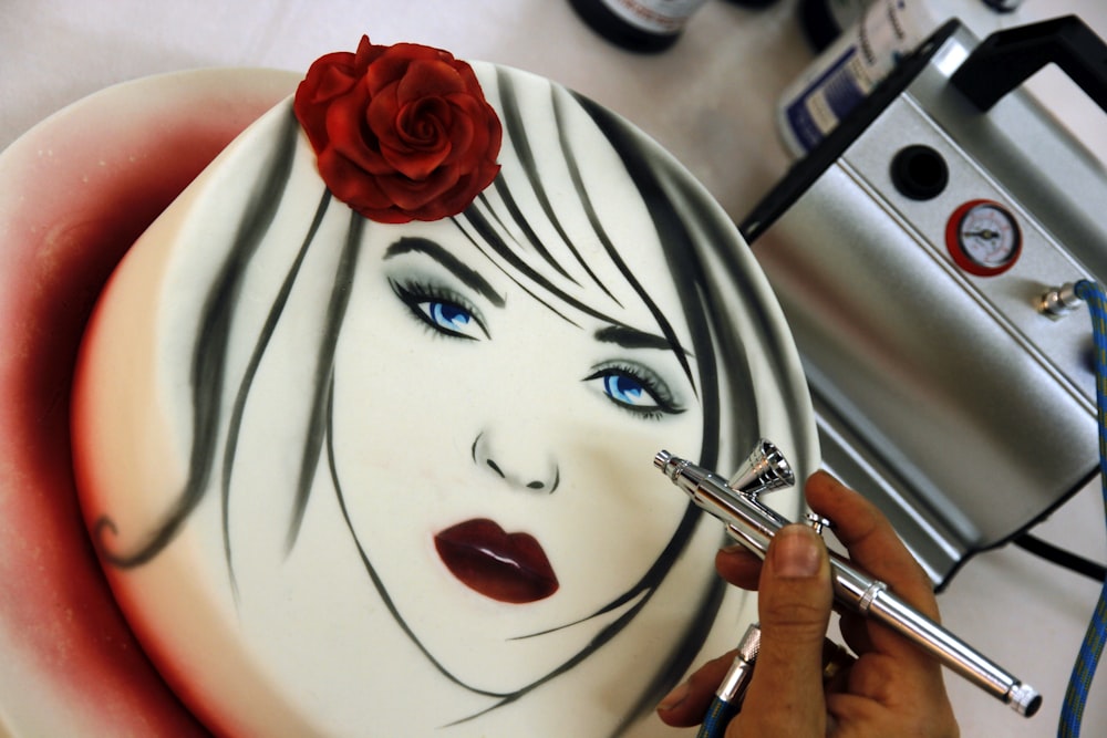 a woman's face is painted on a plate