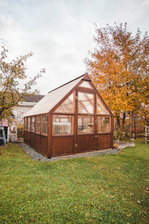 a small wooden building sitting on top of a lush green field