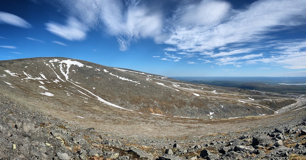 a view of a rocky mountain with snow on it