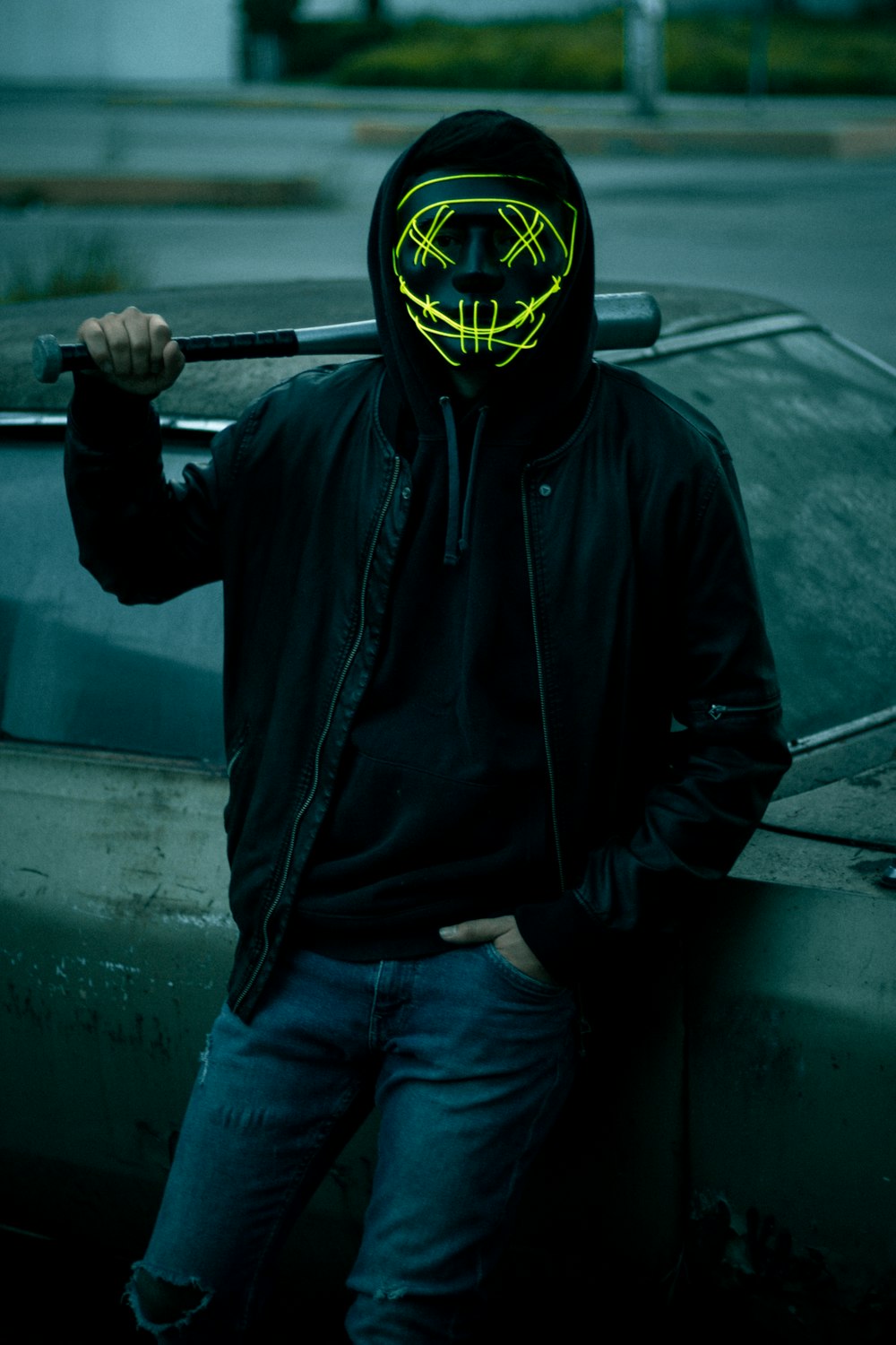 a man with a neon mask holding a baseball bat