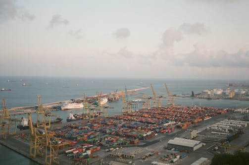 Aerial photo capturing a busy port with several ships docked under a bright sky.