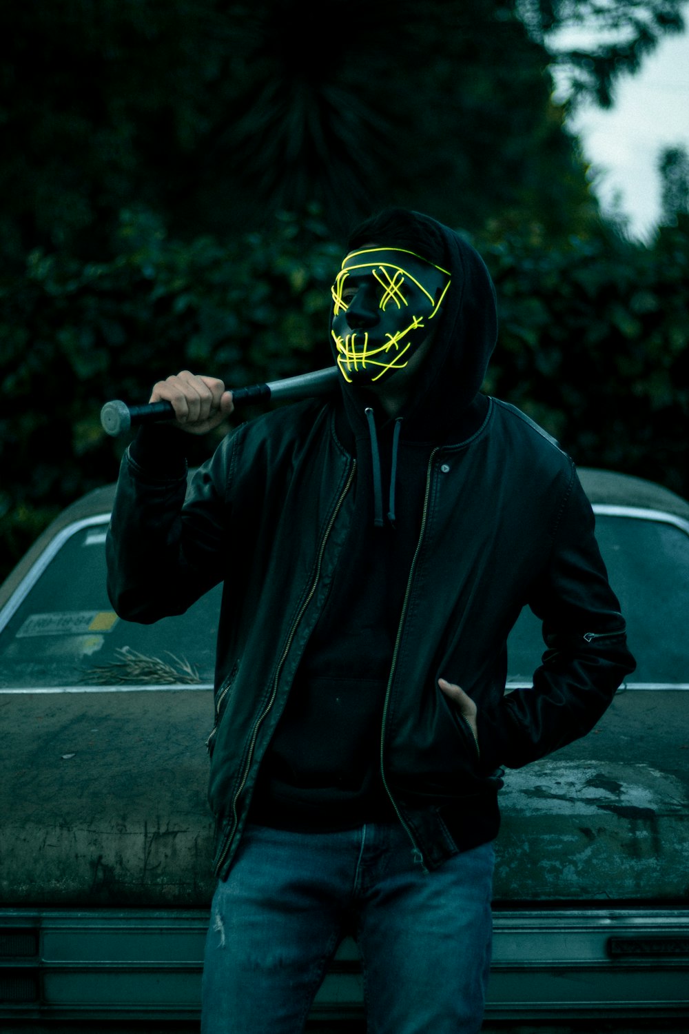 a man with a neon mask holding a baseball bat