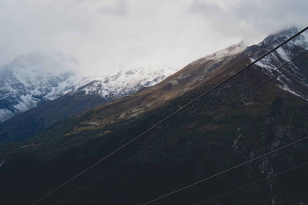 Una vista de una cadena montañosa con líneas eléctricas en primer plano