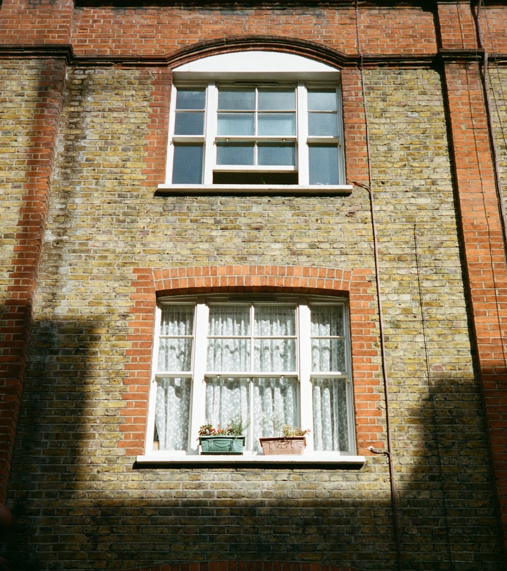 a brick building with a window and a planter