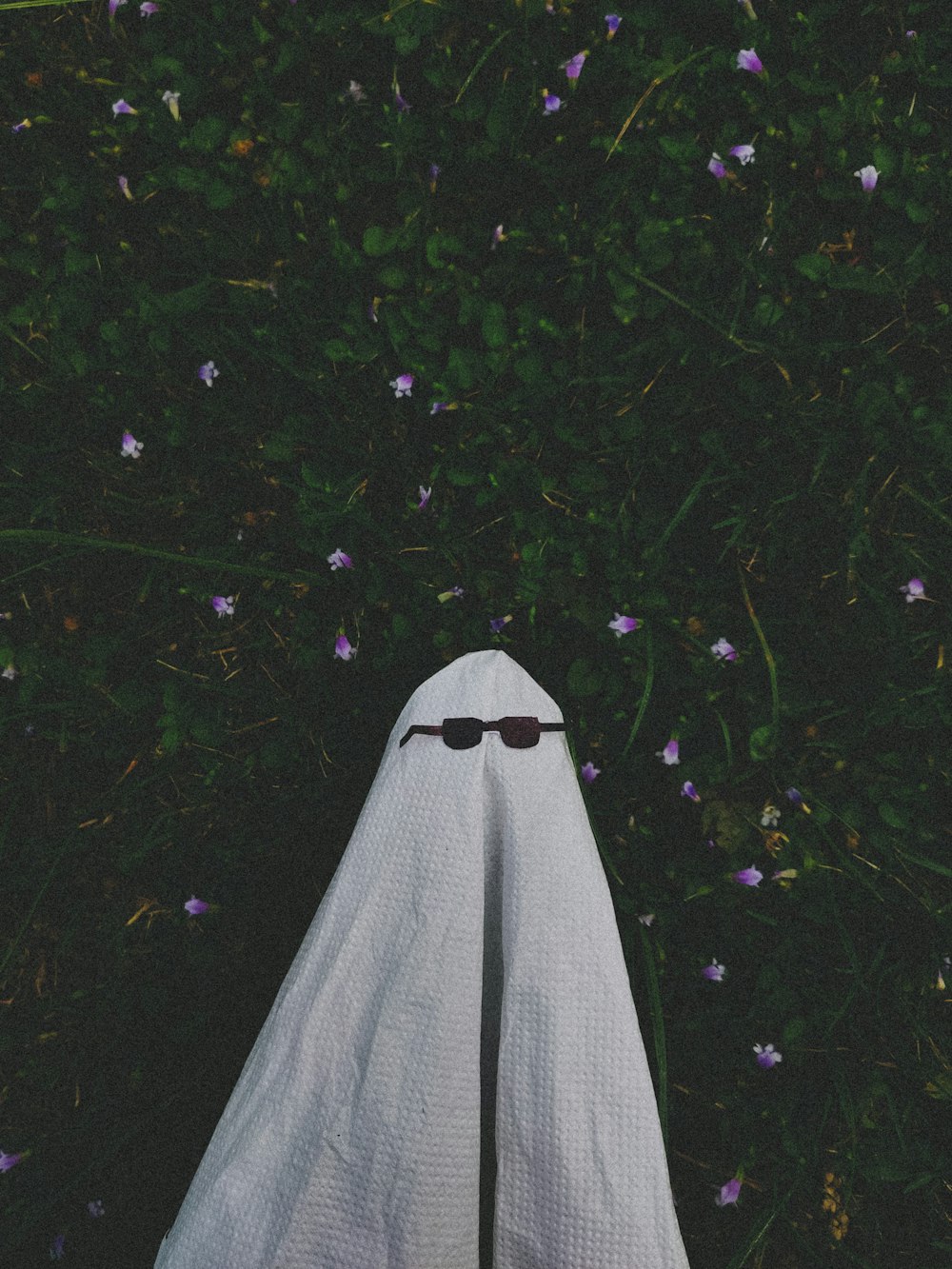 a person's feet with sunglasses and a white cloth covering them