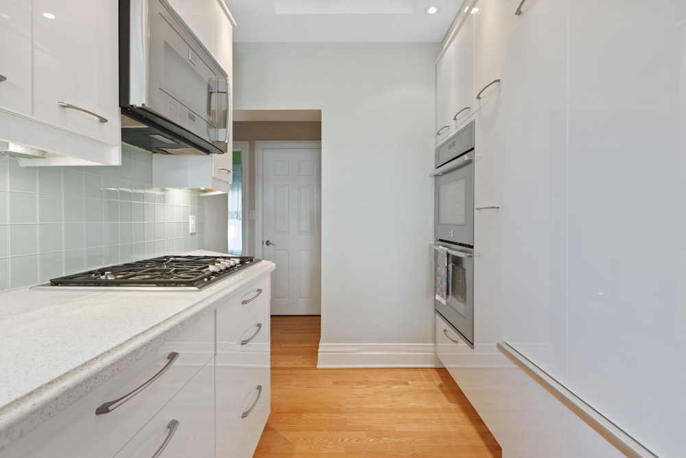 a kitchen with white cabinets and a stove top oven