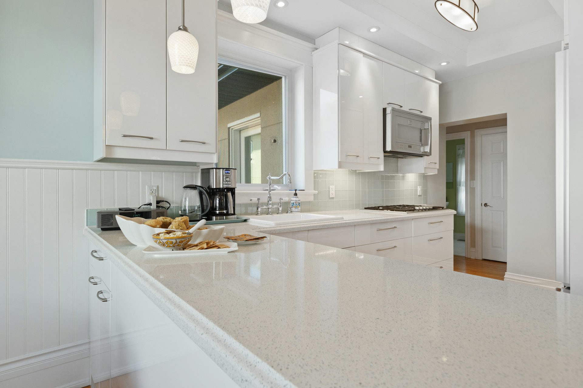a kitchen with white cabinets and counter tops